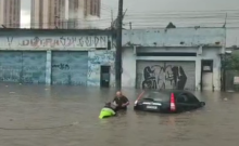Agente de transportes e trânsito no meio do alagamento resgatando munícipe.